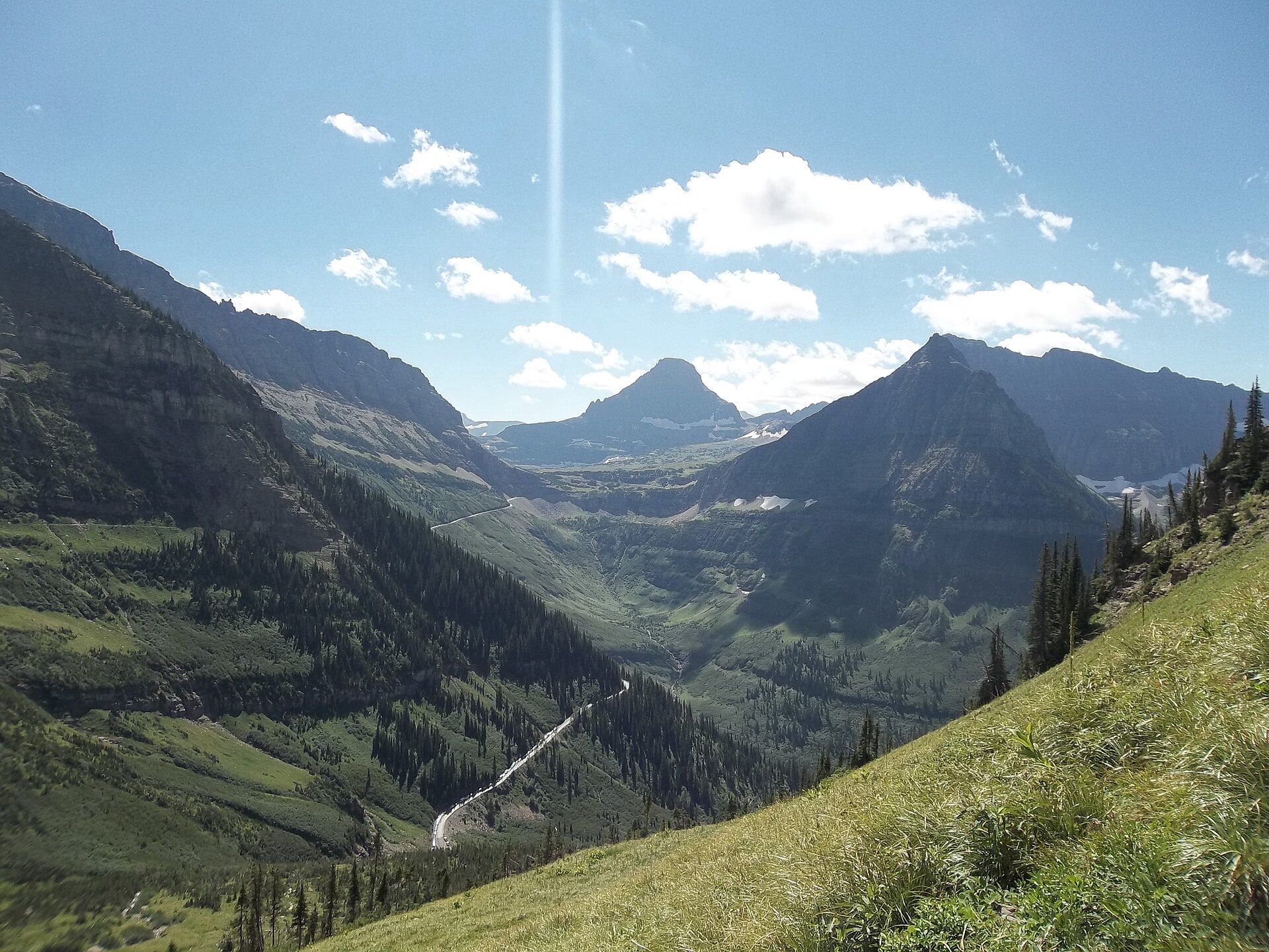 View from Going-to-the-Sun Road over a green valley and peaks in Glacier National Park, Montana