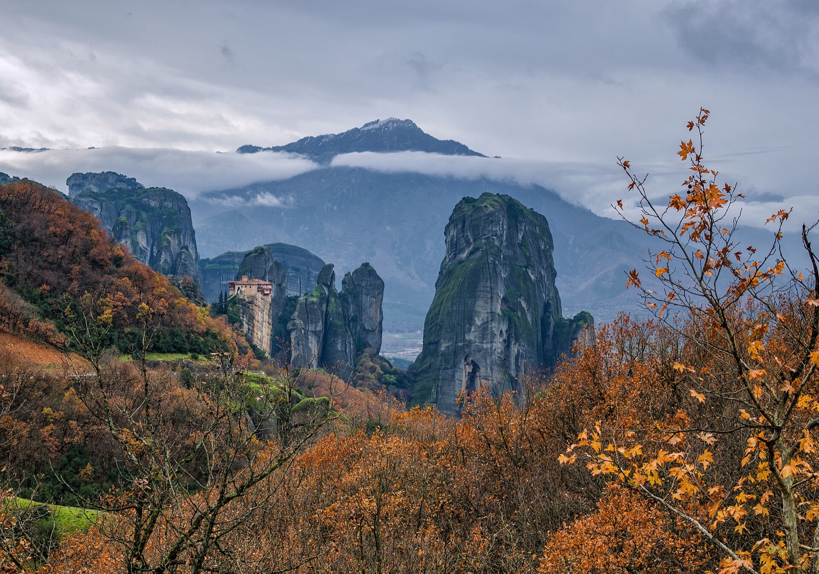 Rousanou Monastery at Meteora in Thessaly, perched on a rock pillar above a wooded valley in autumn colours