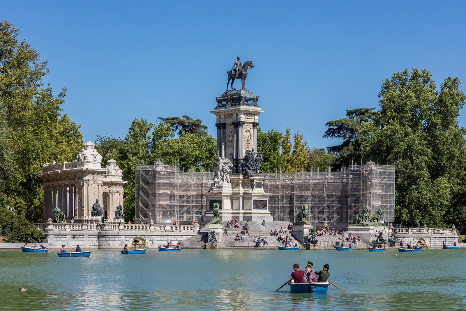 The boating lake and Alfonso XII monument in the Retiro park, Madrid, under a clear sky